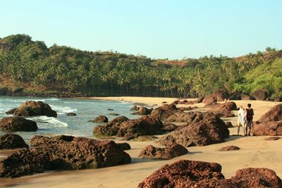 Rocks on beach against clear sky