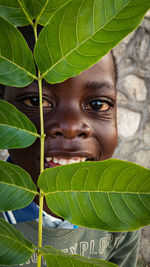Close-up of young child covered with leaves