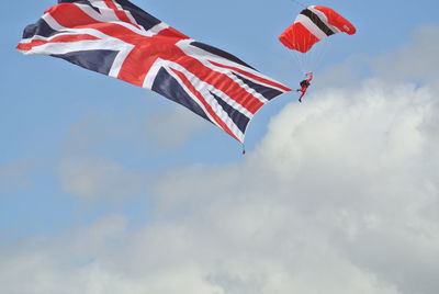 Low angle view of flag waving against sky