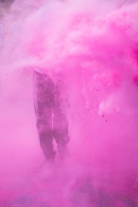 Low section of person standing in pink powder paint