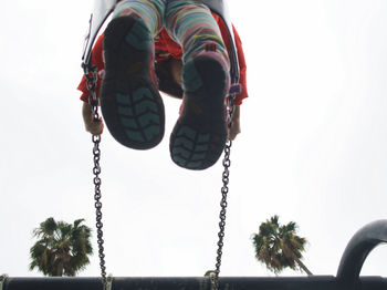 Low angle view of swing hanging against sky