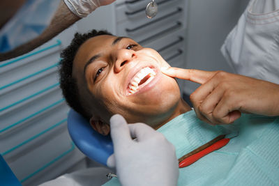 Midsection of dentists examining patient tooth