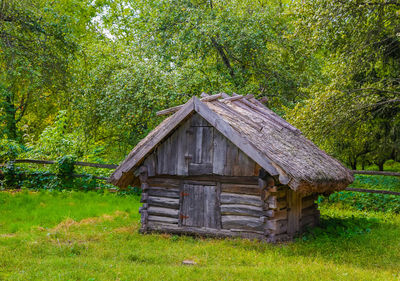 View of wooden house in field