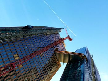 Low angle view of skyscraper against blue sky