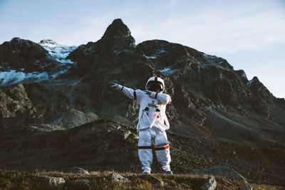 Full length of man standing on rock against sky