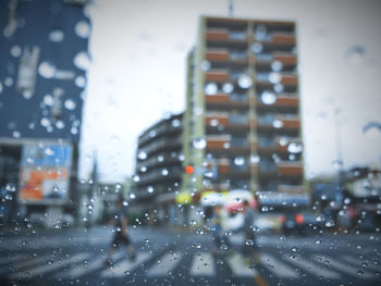 Cars on road seen through wet window