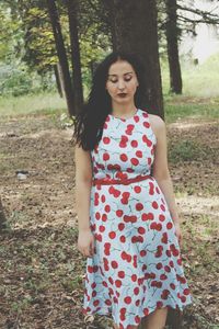 Portrait of young woman standing on field