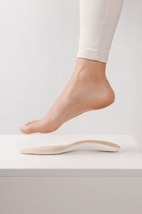 Foot of woman over insole on table