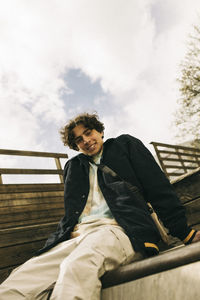 Portrait of smiling teenage boy sitting on steps