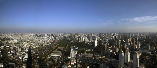 Aerial view of cityscape against blue sky