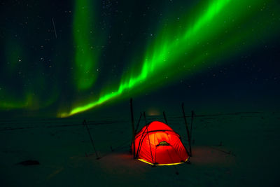 Illuminated tent against sky at night