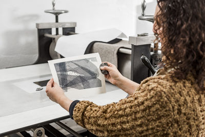 Female artist inspecting the results after operating a manual vi