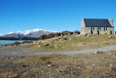 Built structure on field against clear blue sky