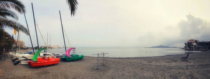 Sailboats moored on sea against sky