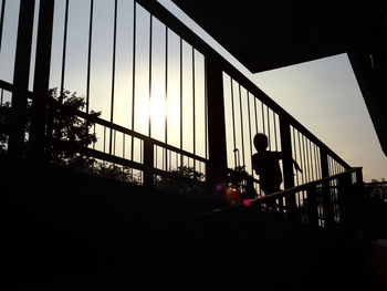 Silhouette people standing on bridge against sky