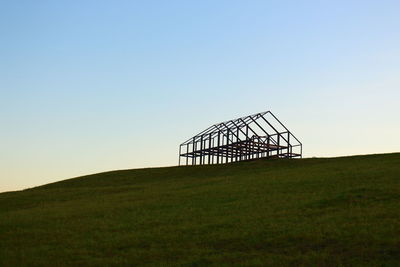 Windmill on field against clear sky