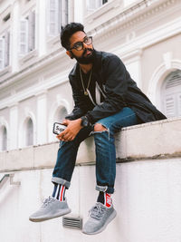 Full length of young man using mobile phone