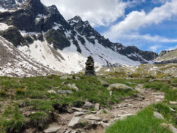 Scenic view of snowcapped mountains against sky, find your direction, rock cairns 