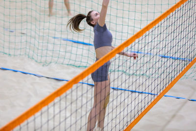 Young girl playing volleyball on the sand