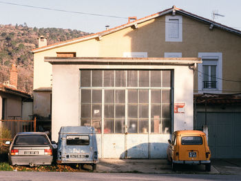 Car on road by buildings in city