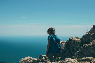 Rear view of man looking at sea against sky