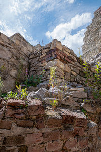 Low angle view of stone wall against sky