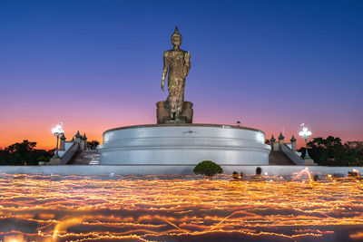 Statue against illuminated clear sky at night