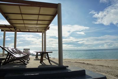 Chairs on beach against sky