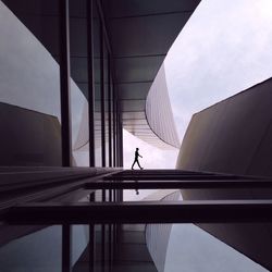 Silhouette person walking outside modern building