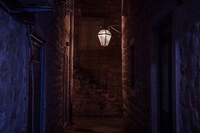 A medieval orange and dark blue old alley with a lantern at night