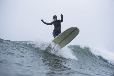 Woman surfing during winter snow