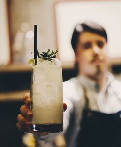 Man holding mojito glass at restaurant