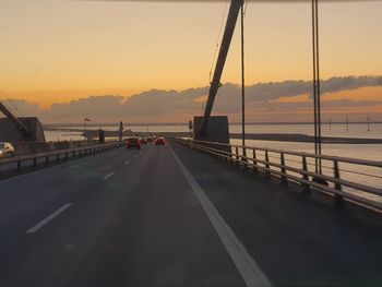 Bridge over road against sky during sunset