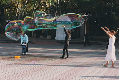 People playing with bubbles at park