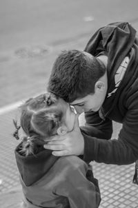 High angle view of siblings with face to face while standing on footpath