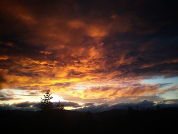 Scenic view of dramatic sky over silhouette landscape