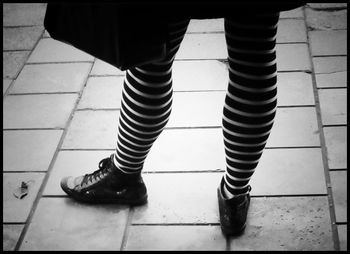 Low section of woman standing on tiled floor