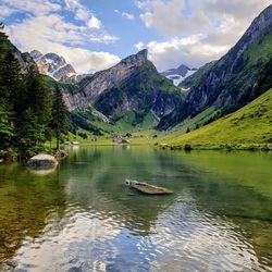 Scenic view of lake by mountains against sky