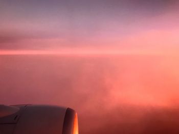 Close-up of airplane against sky at sunset