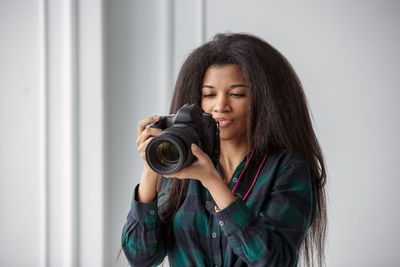 A beautiful african-american photographer girl with a camera. photo shoot in the studio.
