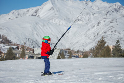 Full length of woman skiing on snow covered mountain