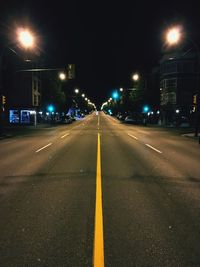Illuminated road against sky at night