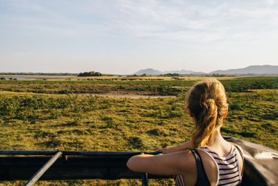 Rear view of woman against agricultural field