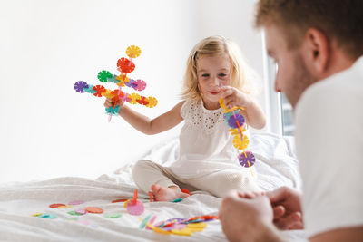 Side view of father and daughter playing with construction 