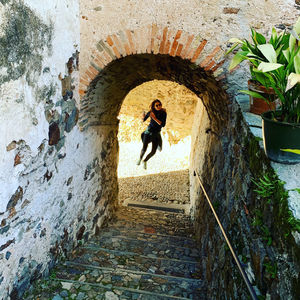 Full length of woman in tunnel against building