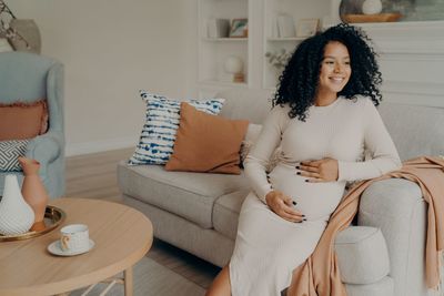 Young woman sitting on sofa at home