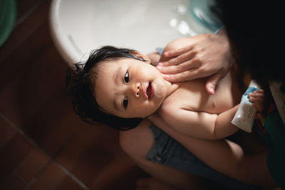 High angle view of cute baby lying on floor