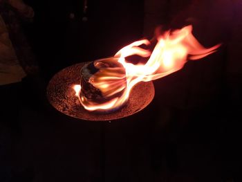 Close-up of lit candle in the dark