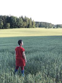 Rear view of woman standing at farm