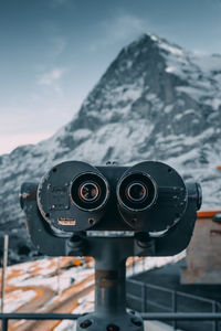 Close-up of coin-operated binoculars against sky